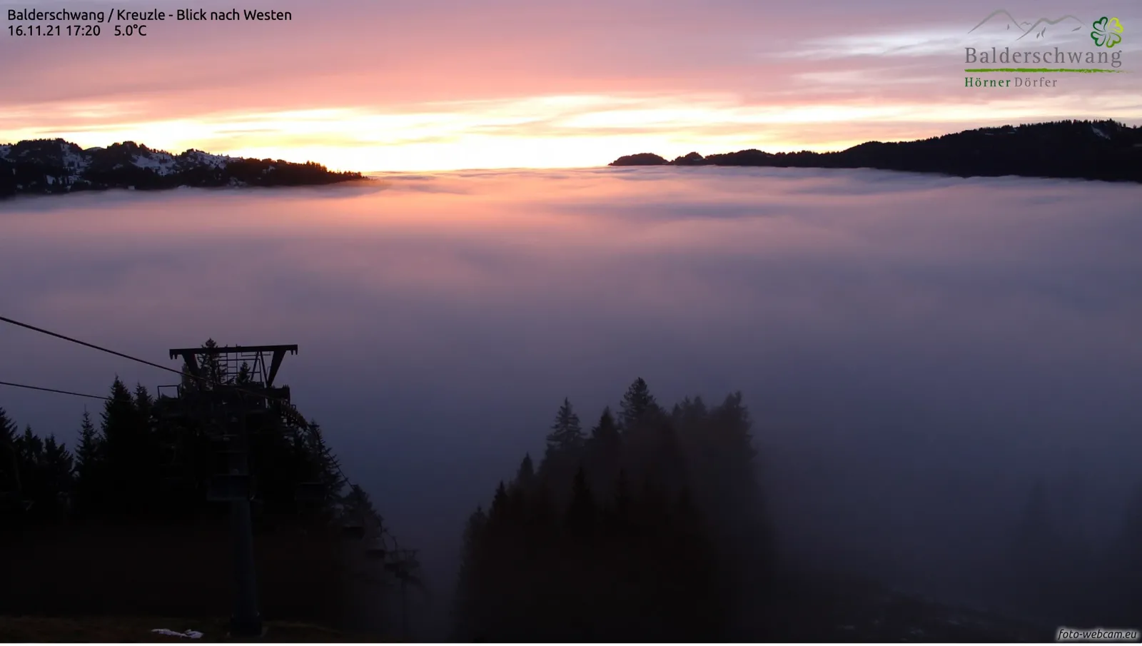 Ein Nebelmeer füllt das ganze Tal bis zum Horizont, darüber ein rosafarbener Himmel