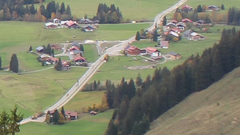 Webcam-Ausschnitt bei Tag: Häusergruppe an der Straße, am Rand ein Haus mit rotem Dach