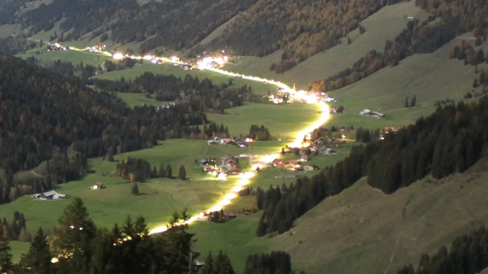Webcam-Blick bei Nacht über das Tal: die beleuchtete Straße schlängelt sich durch den Ort, alles ruhig